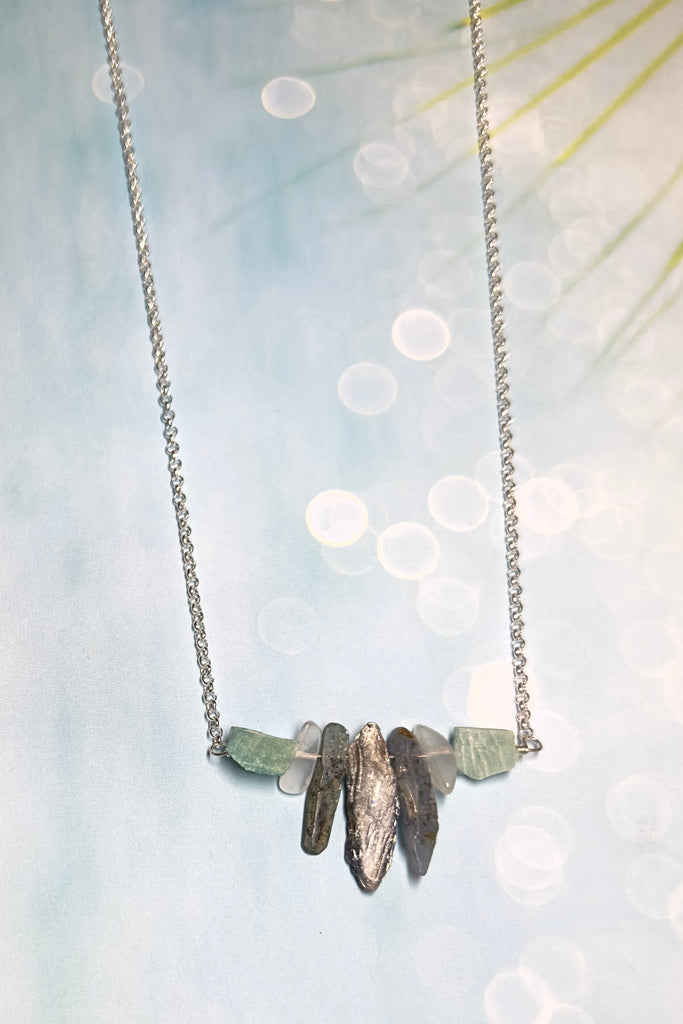 The swing style necklace is designed in a simple and chic style, using rough shards of the semi precious stone Kyanite. 