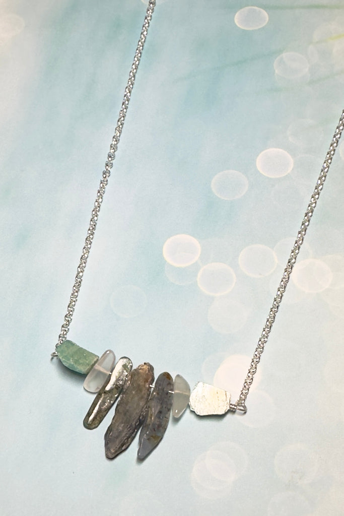 The swing style necklace is designed in a simple and chic style, using rough shards of the semi precious stone Kyanite. 