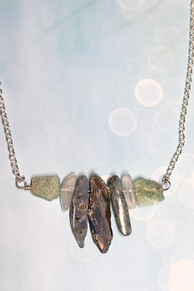 The swing style necklace is designed in a simple and chic style, using rough shards of the semi precious stone Kyanite. 
