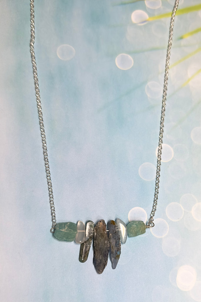 The swing style necklace is designed in a simple and chic style, using rough shards of the semi precious stone Kyanite. 