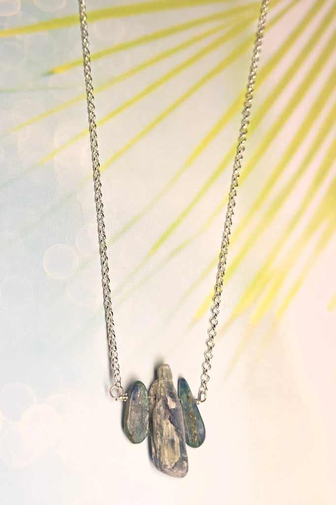 The swing style necklace is designed in a simple and chic style, using rough shards of the semi precious stone Kyanite. 