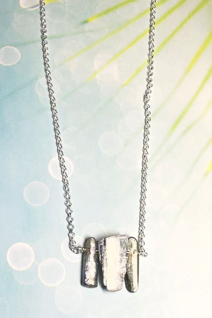 The swing style necklace is designed in a simple and chic style, using rough shards of the semi precious stone Kyanite. 