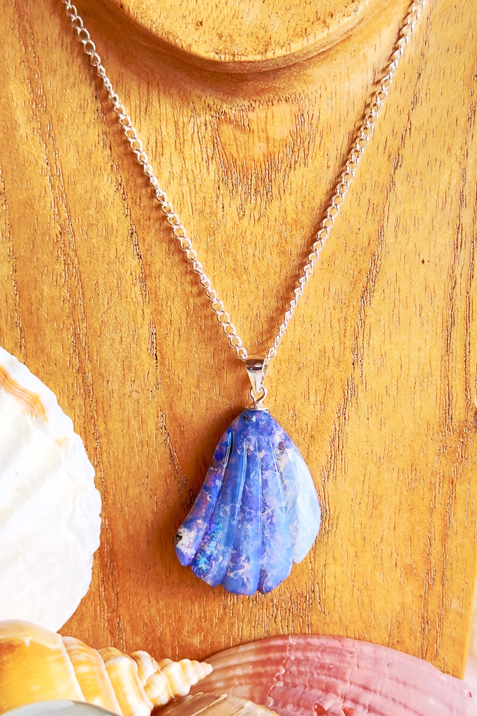 A fascinating and mystical Australian boulder opal pendant carved into in the shape of a scallop shell fragment that could have been found on our beach. It has bright blue and purple flashes of colour under the crystalline surface, revealing the ancient host rock underneath.