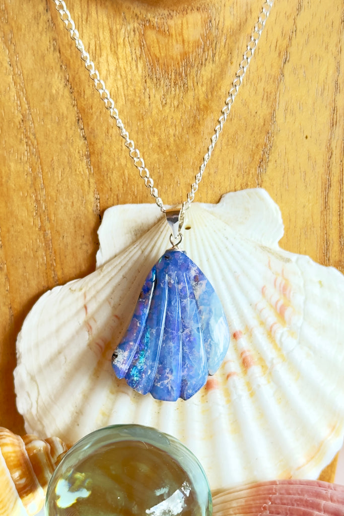 A fascinating and mystical Australian boulder opal pendant carved into in the shape of a scallop shell fragment that could have been found on our beach. It has bright blue and purple flashes of colour under the crystalline surface, revealing the ancient host rock underneath.