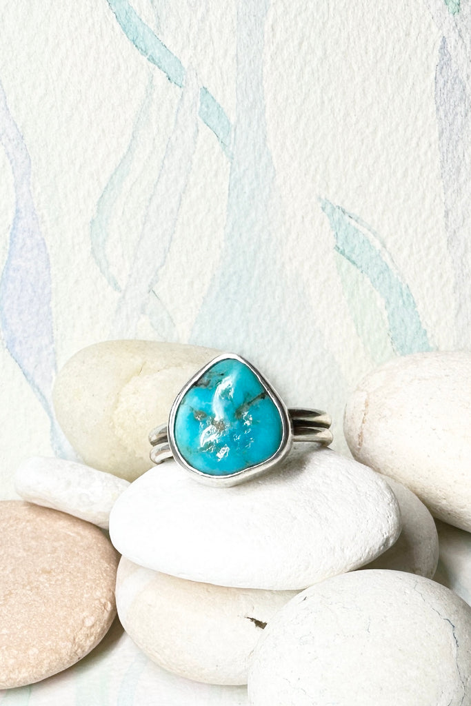 This vintage ring has a solid turquoise centre stone, it is set into a high bezel setting. The band is two rows of silver.