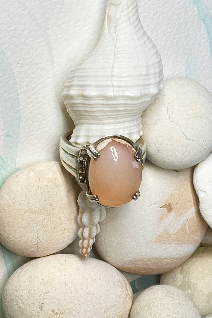 This vintage ring has a solid Mexican Fire Opal centre stone, it is a pretty shade of peachy pink, in a high setting with filigree detail. The band is heavy with some detail, this is a very unique style.