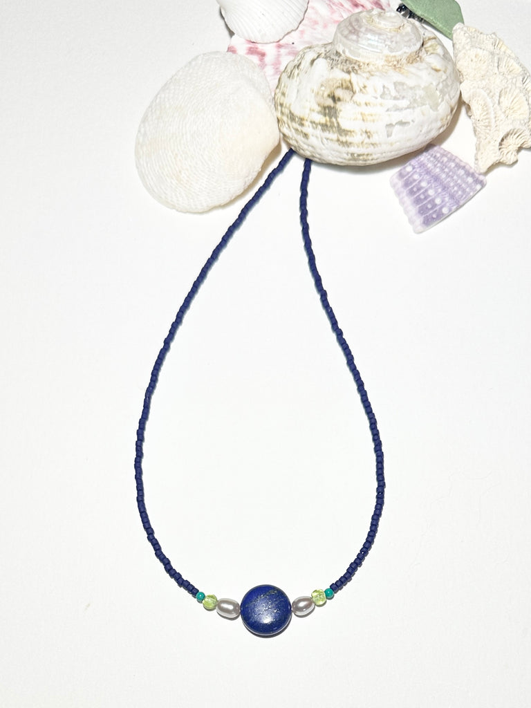 A blue moon and the sea, a tropical night sky and a luminescent pearl, dreaming of cool waters and island romance. A cobalt blue necklace so perfect for summer.


Natural Lapis Lazuli centre bead.
Two pale silvery grey freshwater pearls.