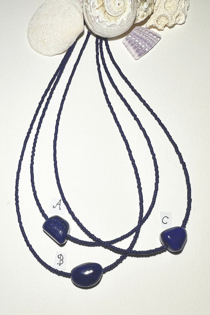 A necklace of blue moon and the sea, a tropical night sky and a luminescent pearl, we are dreaming of cool waters and island romance.


Natural Lapis Lazuli centre bead.
Cobalt blue Afghan "sand" beads.