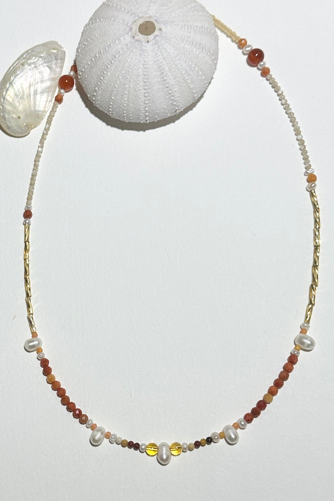A necklace where tiny pearls float on a thread of Russet coloured Australian Mookaite beads, with the accent of golden bugle beads. feel the vibrations of the rock meeting the reef.