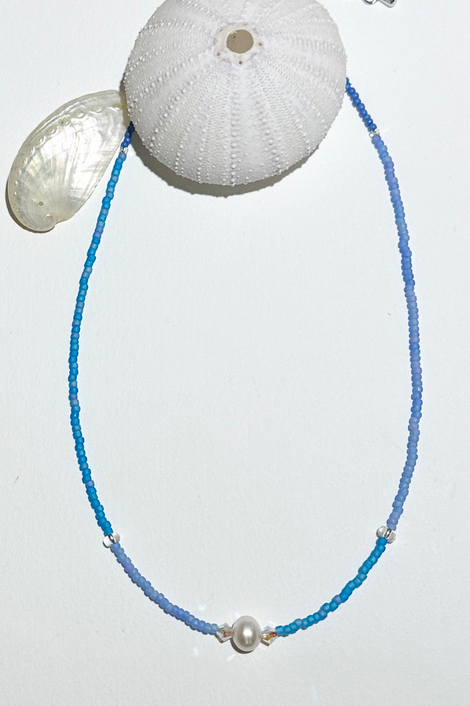 The Necklace Cay Island Gentle Blue is a touch of the clear blue seas, white sand and a pretty pearl.

Freshwater pearl and rock crystal beads.
Glass seed beads.