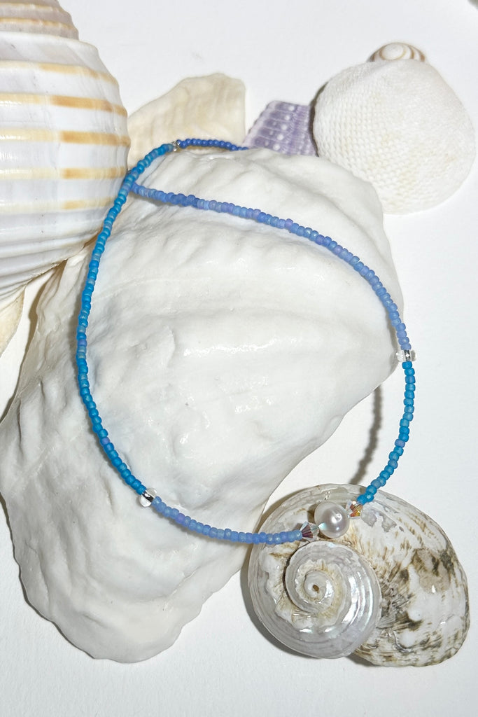 The Necklace Cay Island Gentle Blue is a touch of the clear blue seas, white sand and a pretty pearl.

Freshwater pearl and rock crystal beads.
Glass seed beads.