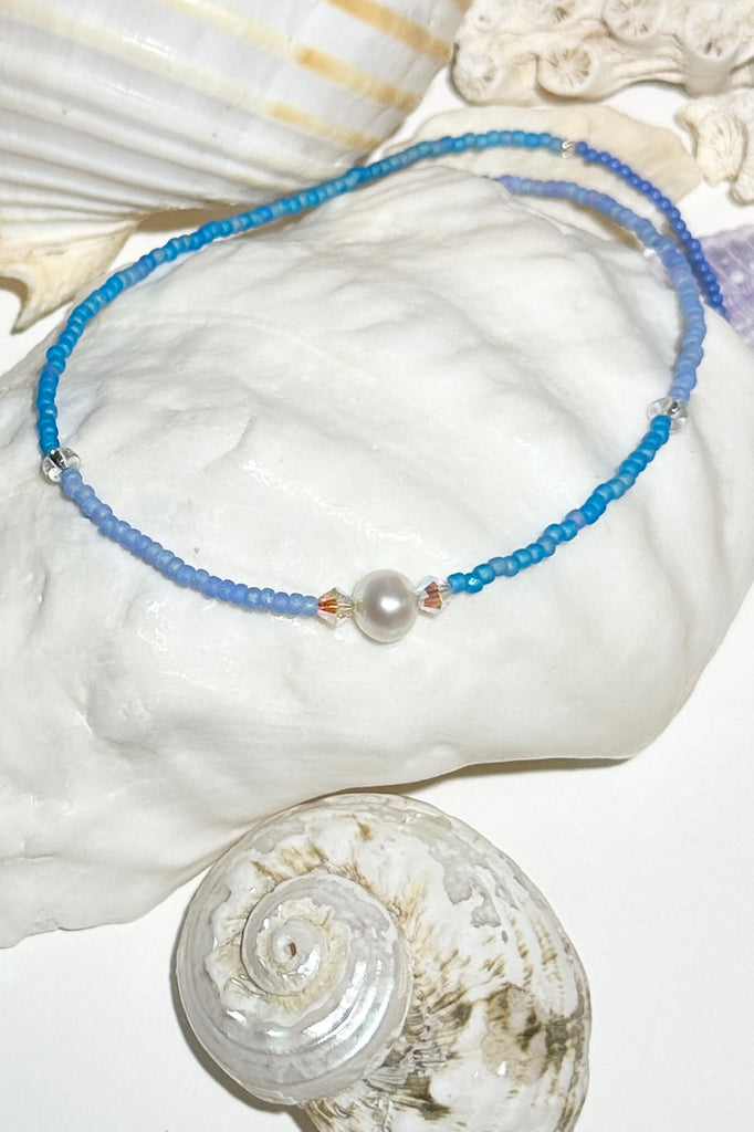 The Necklace Cay Island Gentle Blue is a touch of the clear blue seas, white sand and a pretty pearl.

Freshwater pearl and rock crystal beads.
Glass seed beads.