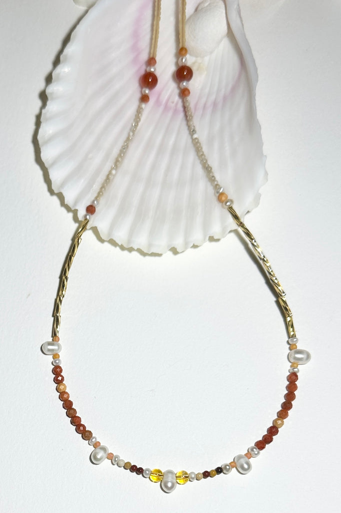 A necklace where tiny pearls float on a thread of Russet coloured Australian Mookaite beads, with the accent of golden bugle beads. feel the vibrations of the rock meeting the reef.