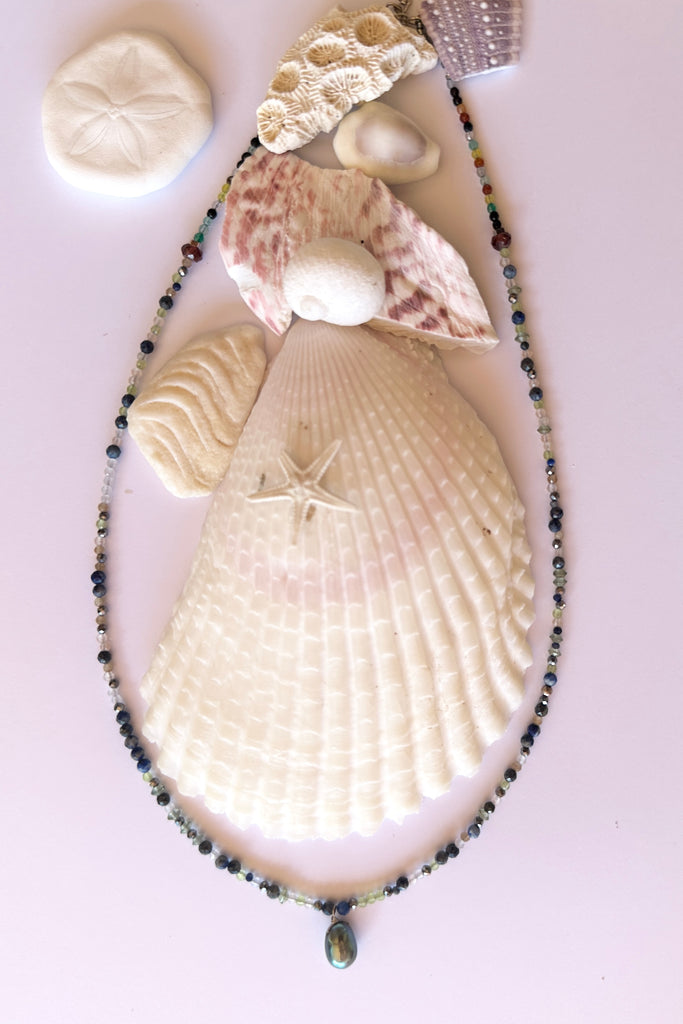 A Pretty pearl strung on a necklace of tiny faceted gemstone beads, Its chic and delicate and perfect for summer.

Freshwater pearl.
Lapis, Peridot, garnet and quartz crystal beads.&nbsp;