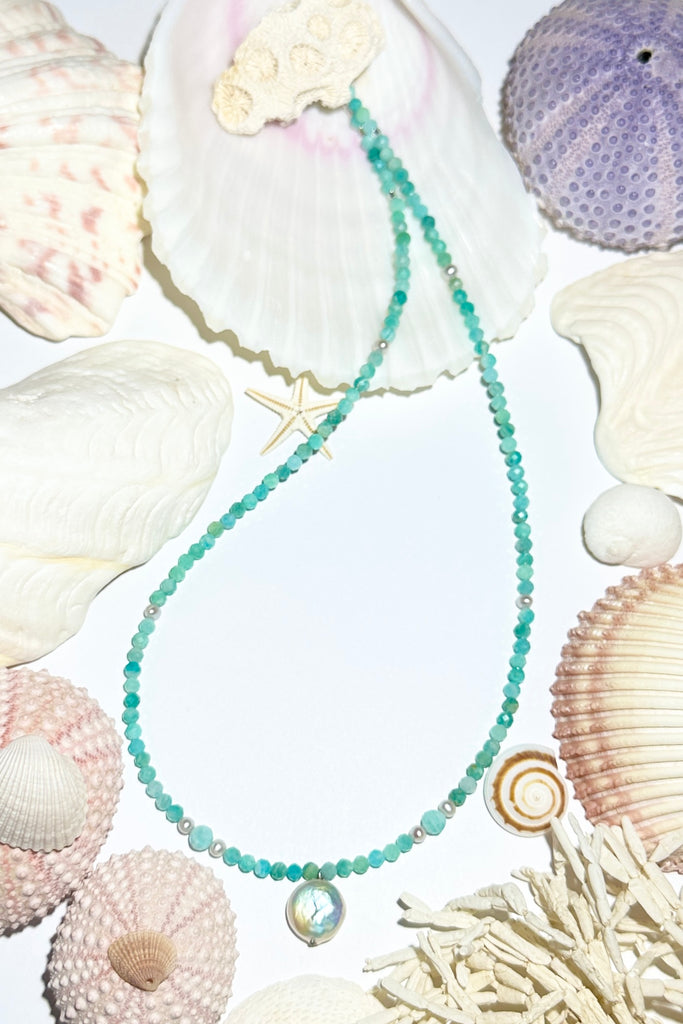 A pearl necklace where tiny pearls float on a thread of faceted Amazonite and pearl beads, inspired by the gentle waves of South Pacific reef lagoon.

Freshwater pearls.
Faceted aqua blue Amazonite beads.