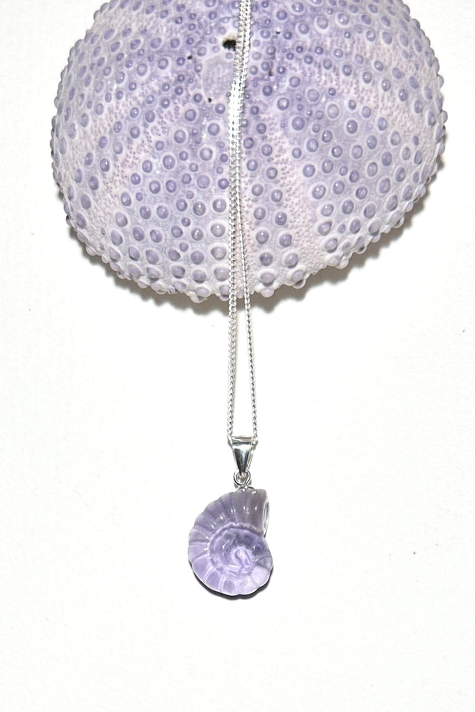 A Fluorite gemstone that has been hand carved into a tiny nautilus sea shell, it has a magical prettiness all of its own.&nbsp;

Fluorite gemstone hand carved into a nautilus sea shell
Pendant is 2.5cm long including the bail.