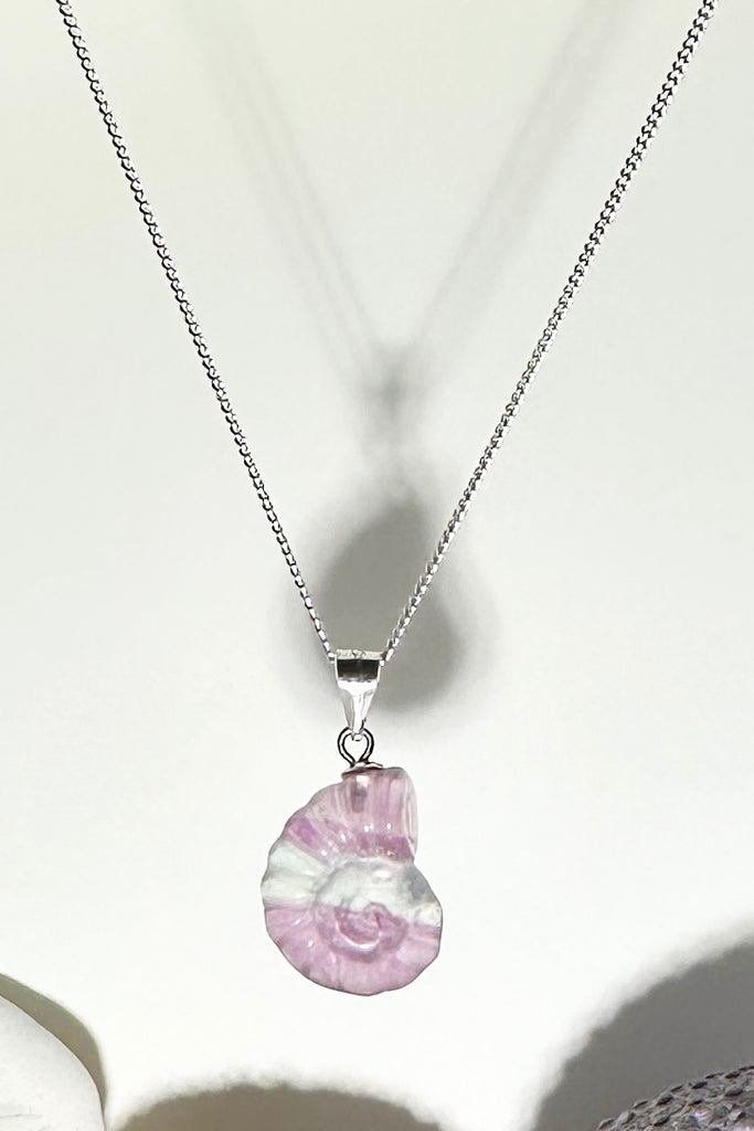 A Fluorite gemstone that has been hand carved into a tiny nautilus sea shell, it has a magical prettiness all of its own.

Fluorite gemstone hand carved into a nautilus sea shell