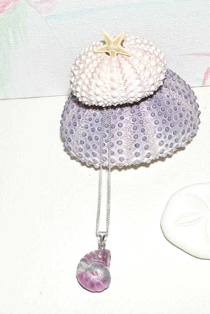 A Fluorite gemstone that has been hand carved into a tiny nautilus sea shell, it has a magical prettiness all of its own.&nbsp;

Fluorite gemstone hand carved into a nautilus sea shell