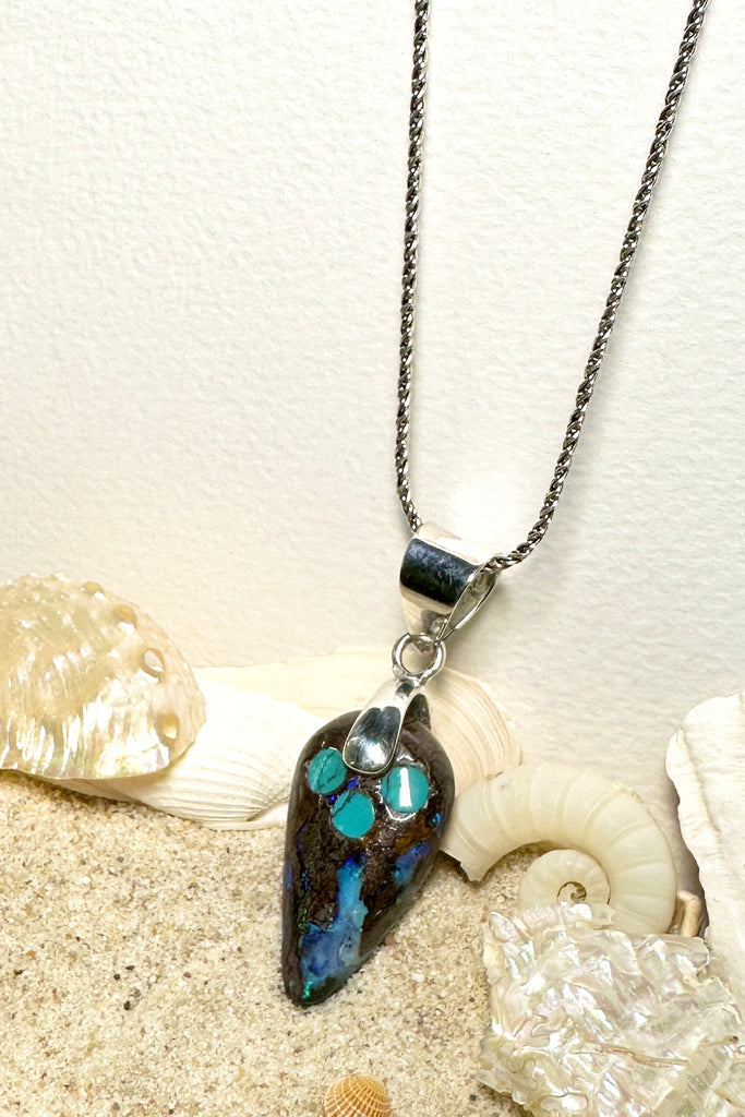 The opal has deep rivulets of very bright blue with green flashes and a sparkle of red. An Australian solid boulder opal pendant which has been inlaid with Arizona Turquoise. The pendant bail is silver Solid Australian Boulder Opal.