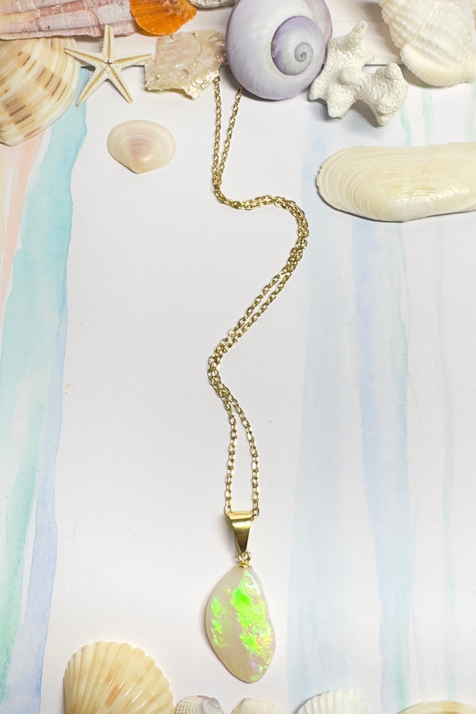 Australian solid crystal opal pendant cut into a freeform drop shape. Lovely bright green, flashing across the stone.