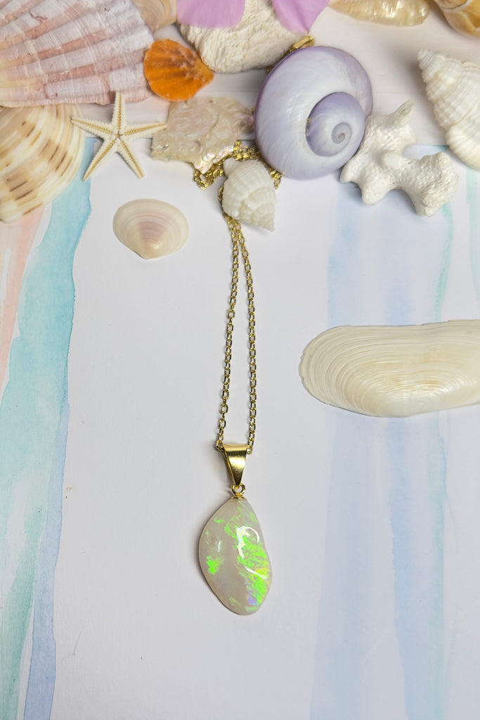 Australian solid crystal opal pendant cut into a freeform drop shape. Lovely bright green, flashing across the stone.