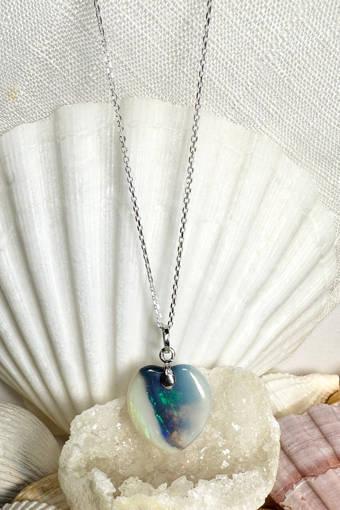 A very magical opal stone, with a windswept cloud of green, blue and red sparkle down the centre.  Opal heart pendant with blue, green and red sparkle down the centre.  Sides are pale crystalline with a tiny flash.  Solid boulder opal.