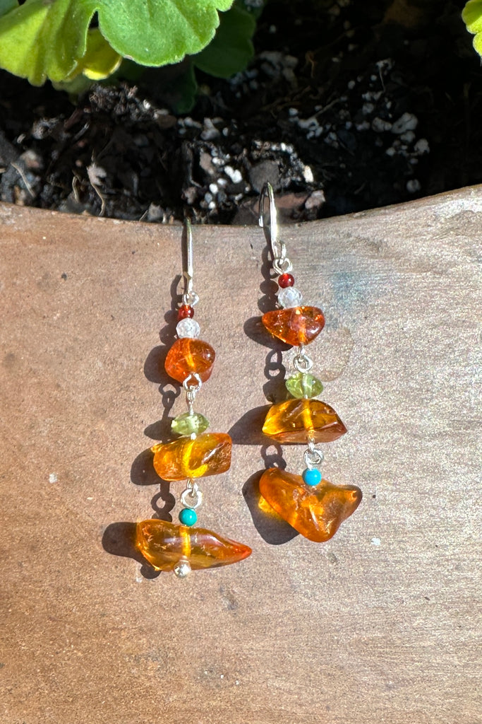 Baltic Amber earrings that dance in the sunlight or in the firelight on a winters evening.

Natural Baltic Amber.
Turquoise, Peridot and Garnet tiny beads.