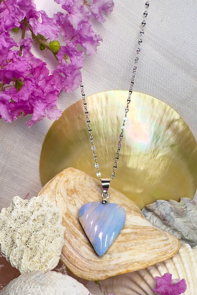 The rhythm of the sounds of the ocean swirl quietly across the face of this Opal pendant like the waves reaching a shoreline. 