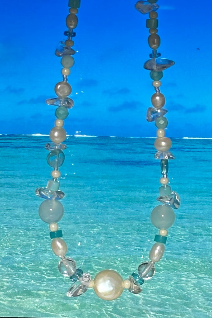Perfectly luminescent pearls in a ocean splash of aqua and crystal, a pearl necklace that has the colours and the calm of the tropical island waters. A lucky coin pearl as the centrepiece.

Freshwater pearls in assorted sizes and colours.
Amazonite, Rock Crystal, Quartz, and Mother of pearl beads.