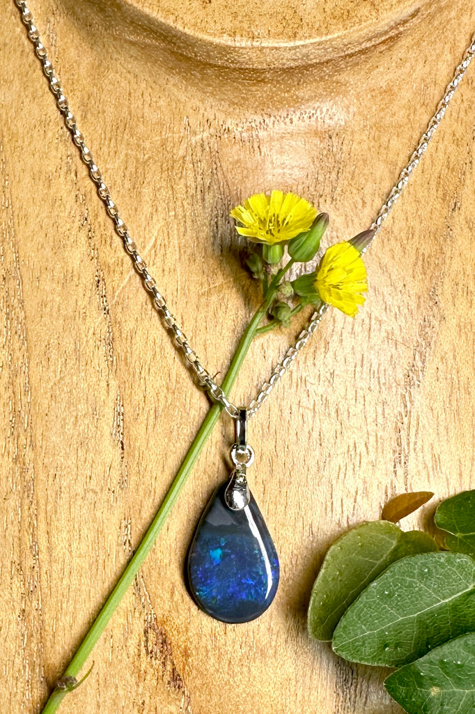 wonderful deep blue flashes run deep through the black rock on this droplet shaped opal pendant