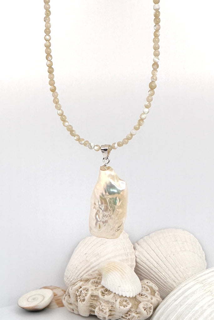 Seaside romance, this large Baroque pearl hangs off a necklace of tiny shiny Mother of pearl seed beads, minimal with a touch of chic.