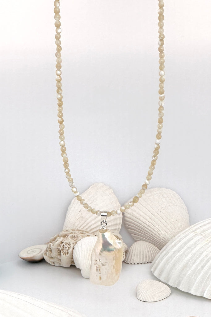 Seaside romance, this large Baroque pearl hangs off a necklace of tiny shiny Mother of pearl seed beads, minimal with a touch of chic.
