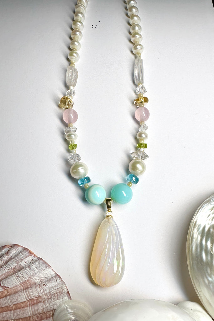  beautiful creamy pink hand carved crystal opal with subtle flashes of green and blue, on a necklace of small lustrous pearls with gemstone highlights