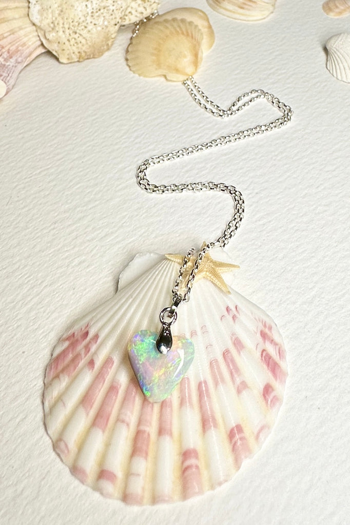 A heart shaped opal pendant with pretty flashes of bright green, gold and misty mauve blue, 