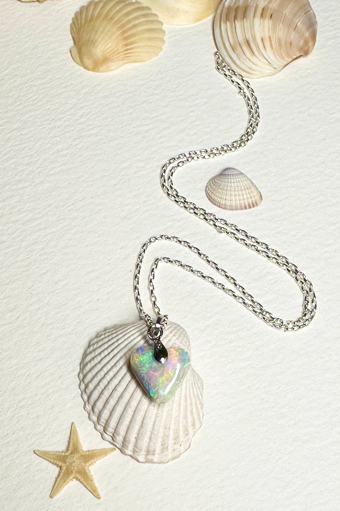 A heart shaped opal pendant with pretty flashes of bright green, gold and misty mauve blue, 