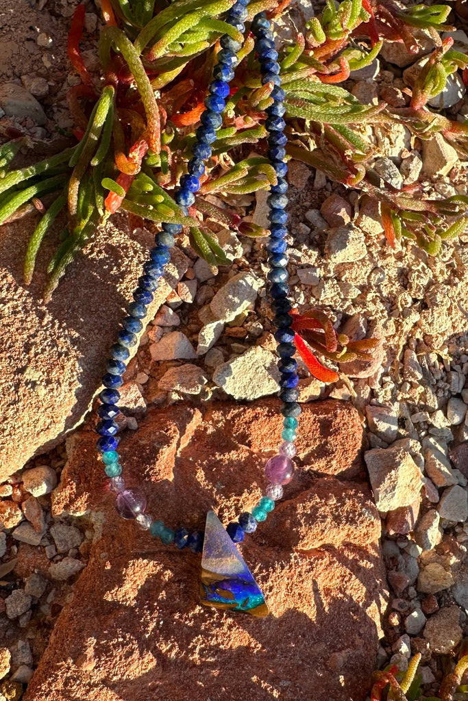 A bright splash of blue, a river of brightest green and an amethyst sky. A solid opal with the intensity of bright colour that is absolutely unique, on a deep blue Lapis Lazuli faceted bead necklace.
