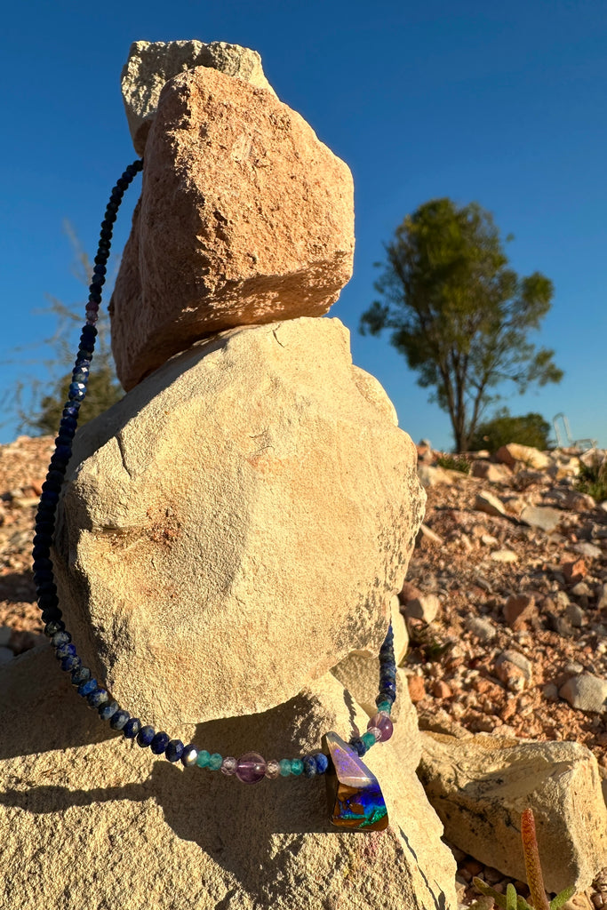 A bright splash of blue, a river of brightest green and an amethyst sky. A solid opal with the intensity of bright colour that is absolutely unique, on a deep blue Lapis Lazuli faceted bead necklace.