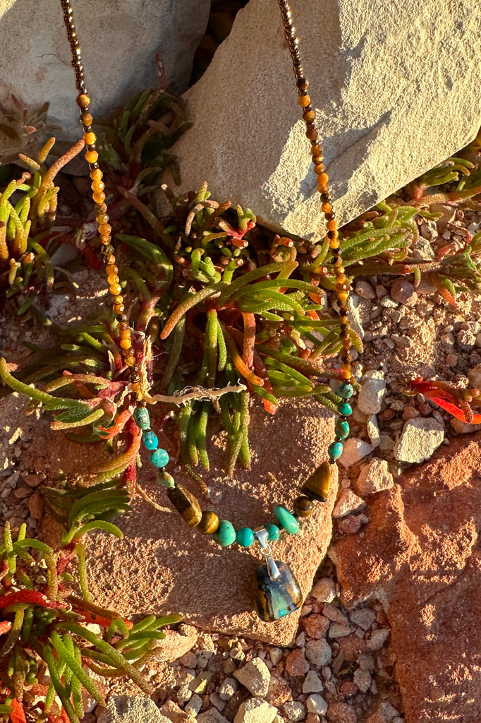 Solid Boulder Opal pendant with with Natural Arizona Turquoise and Tigers Eye beads.
Opal has a misty mauve drifting down the stone with a very bright pool of green at the base.
