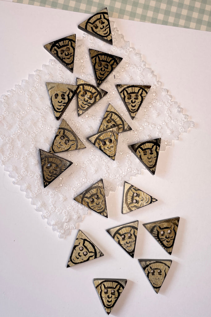 These quirky little triangle buttons are carved from horn and are extremely unusual.