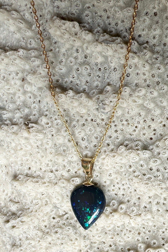 This Australian black opal pendant has bright blue and teal flash deep in the stone.