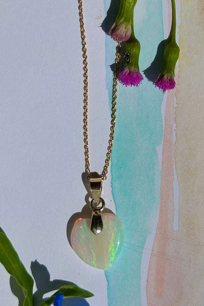 a really lovely opal heart pendant the crystal has shimmer in pink, green, and gold, the shape is very pure and harmonious. Romance in a stone