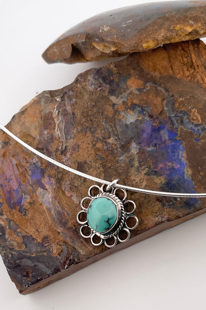 This lovely old turquoise pendant is a one off piece. Artisan set into unmarked silver, it is a flower shape, it hangs from a good 925 silver omega chain necklace. 