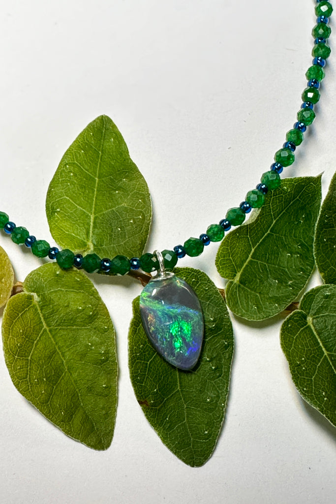 tiny, delicate and pretty opal pendant, it has bright blue and green dancing across the stone, on an emerald green quartz necklace