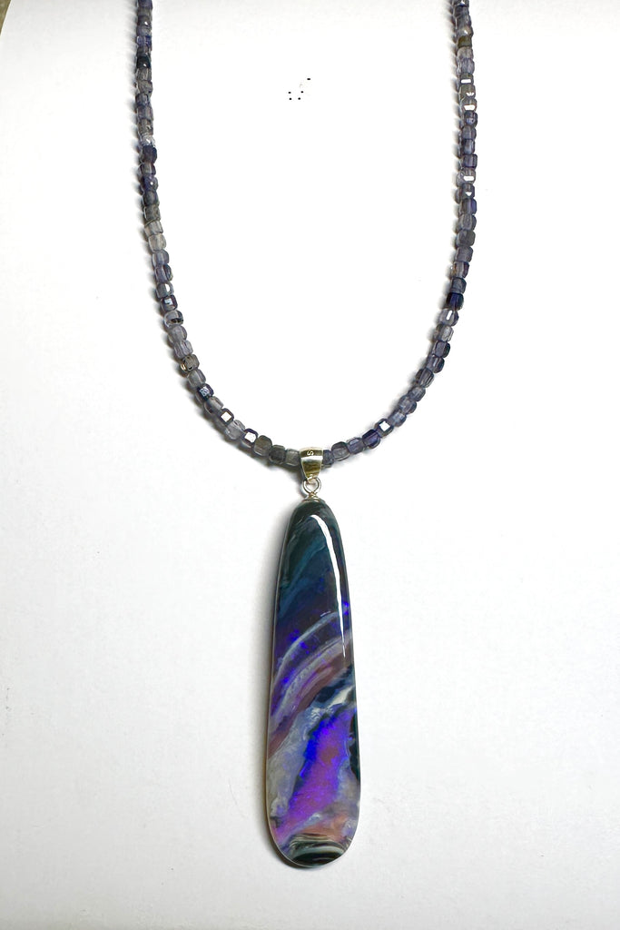 This black Opal pendant is an absolute stunner, a wonderous slice of opal heaven, black and grey base with bright purple and blue crystal swirling across and white clouds as a highlight.