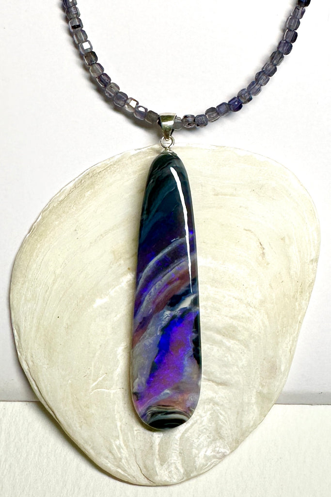 This black Opal pendant is an absolute stunner, a wonderous slice of opal heaven, black and grey base with bright purple and blue crystal swirling across and white clouds as a highlight.