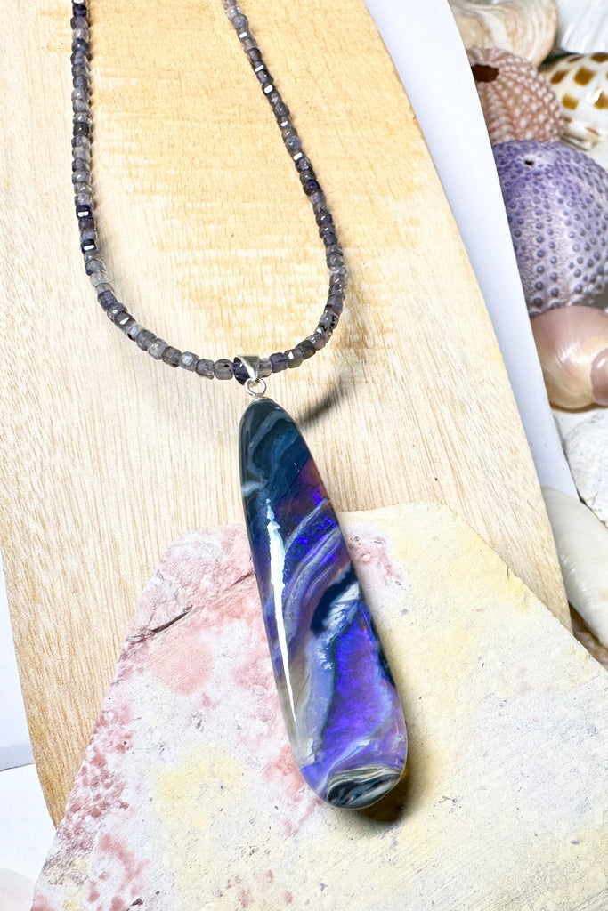 This black Opal pendant is an absolute stunner, a wonderous slice of opal heaven, black and grey base with bright purple and blue crystal swirling across and white clouds as a highlight.