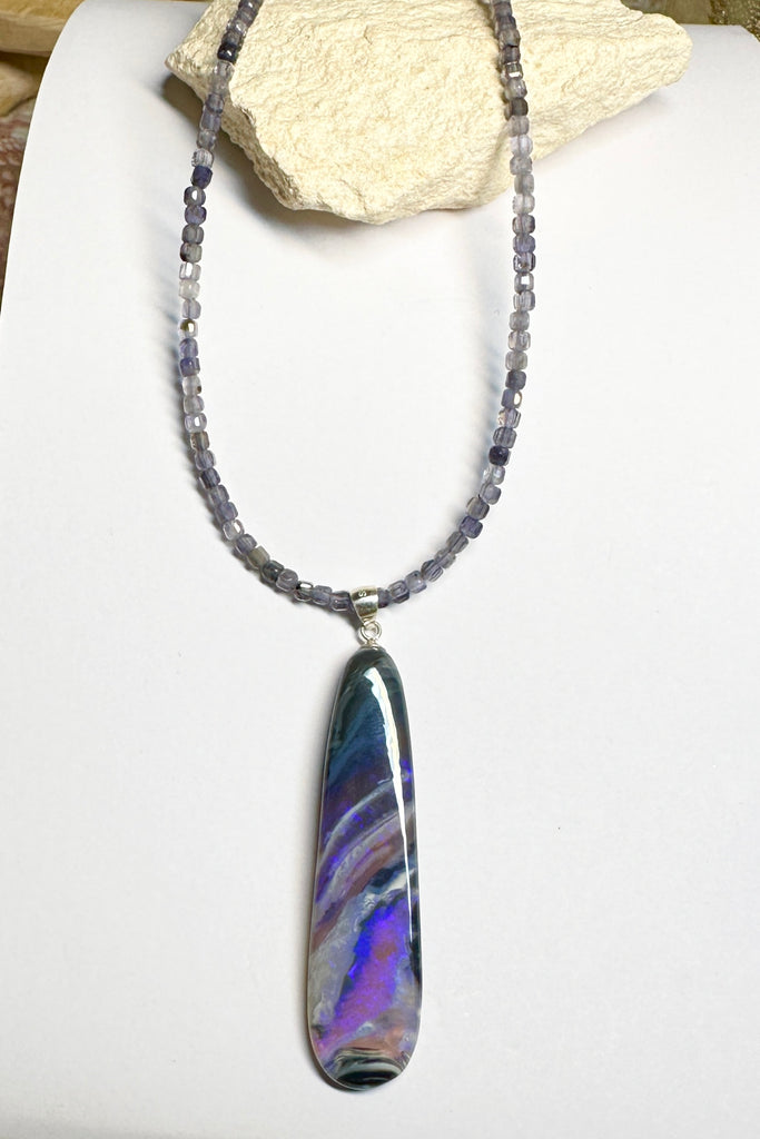 This black Opal pendant is an absolute stunner, a wonderous slice of opal heaven, black and grey base with bright purple and blue crystal swirling across and white clouds as a highlight.