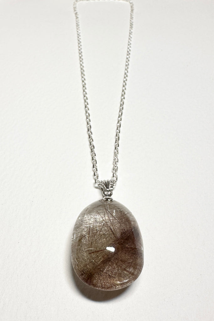 natural crystal pendant polished to a high shine, this stone is cut into a strong oval shape with the Rutile needles dense throughout