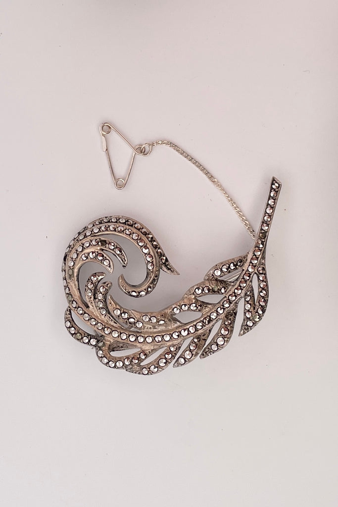 sterling silver sparkling marcasite brooch in the form of a feather. The vintage brooch is made of sterling silver and is entirely lined with dazzling marcasite gems. 