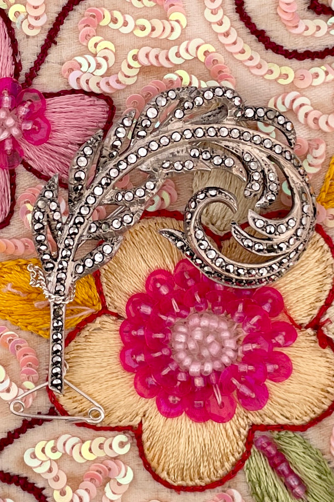 sterling silver sparkling marcasite brooch in the form of a feather. The vintage brooch is made of sterling silver and is entirely lined with dazzling marcasite gems. 